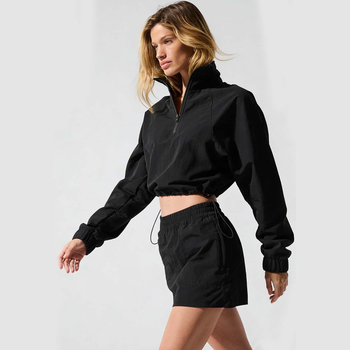 Women’s black half-zip jacket and mini skirt set, cropped length