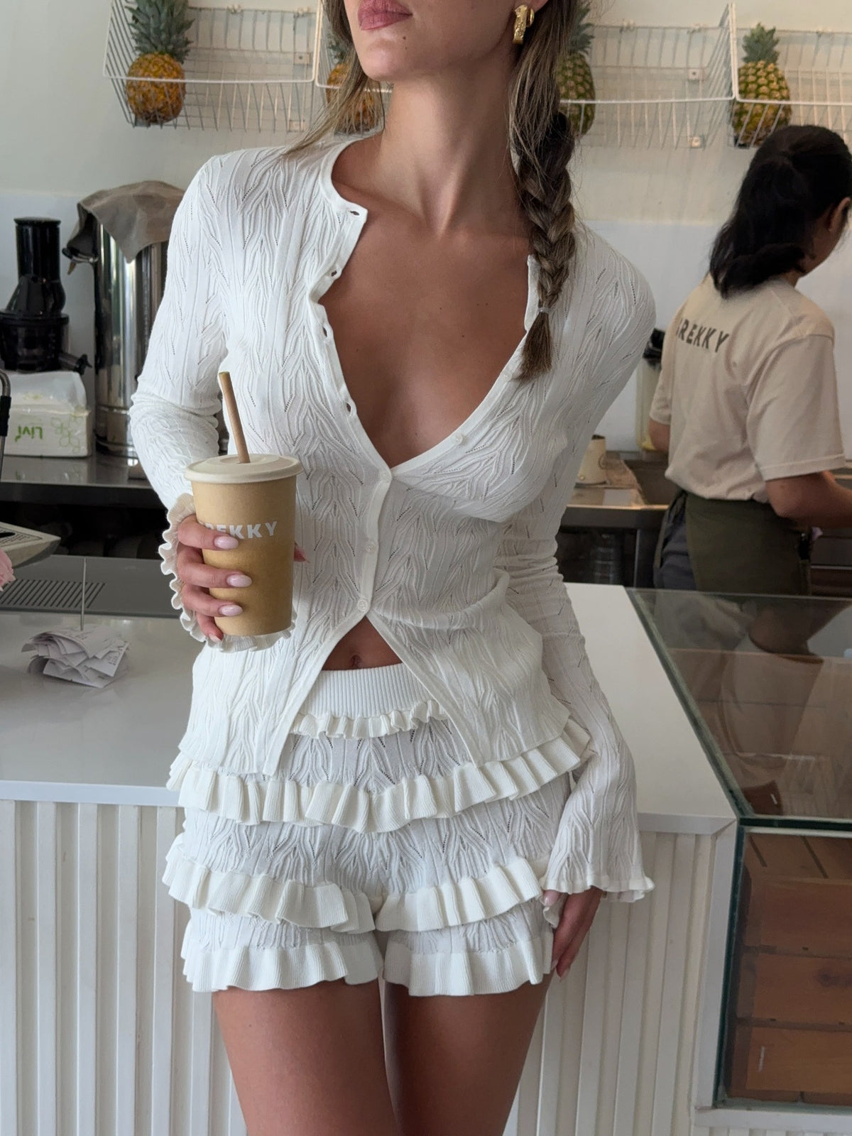 White knitted long-sleeve cardigan with deep V-neck and tiered ruffle trim