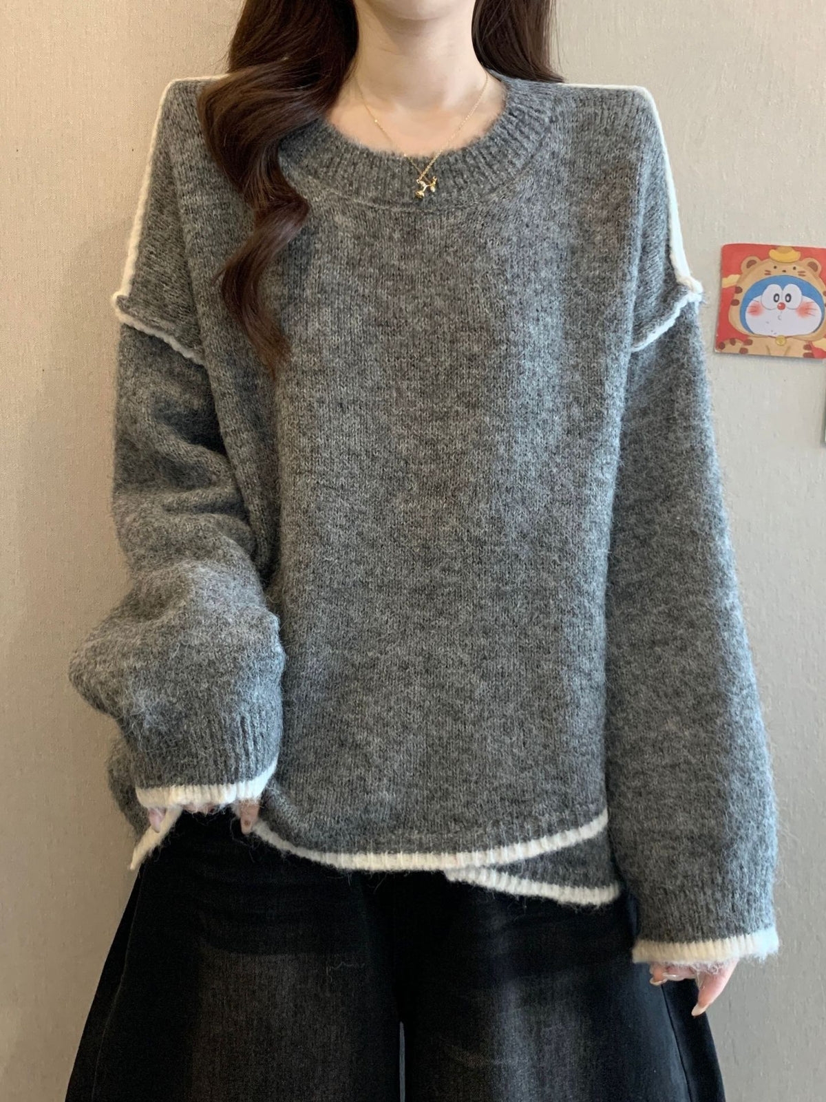 Gray textured knit sweater with white-and-black striped hem and long sleeves