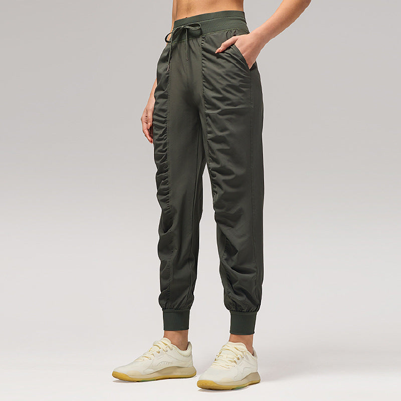 Women’s loose dark green jogger pants with drawstring waist and cuffed ankles, side pockets.