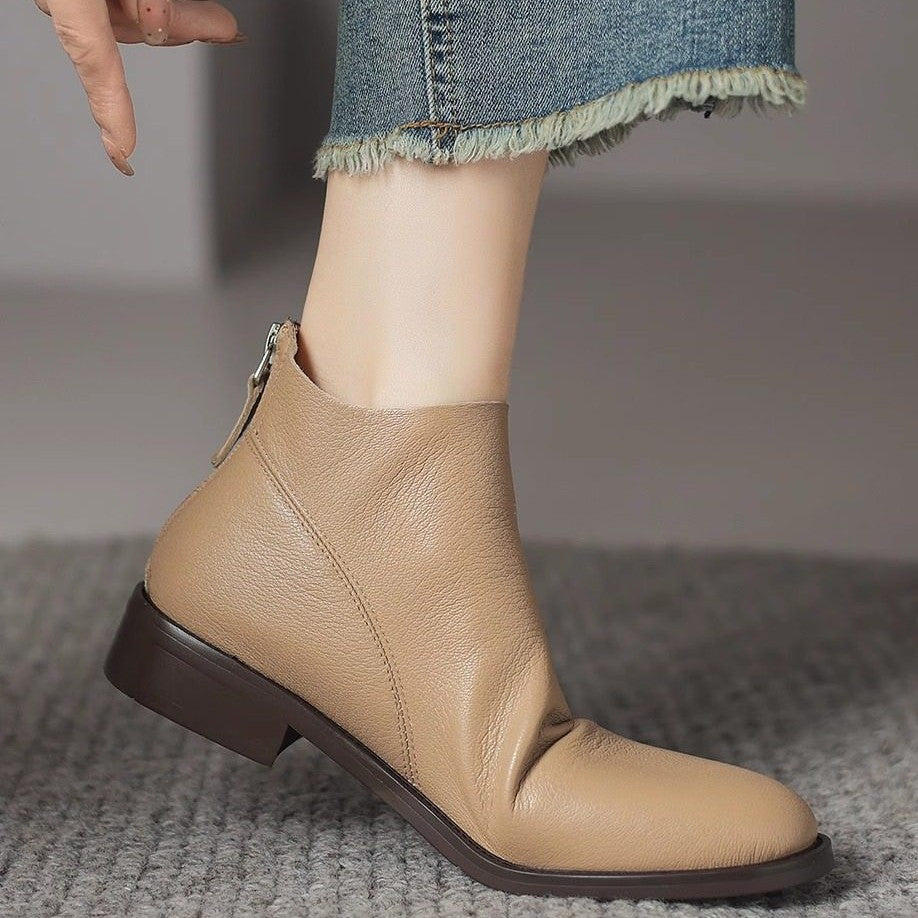 Women’s light off-white short boots with chunky heel and side zipper pull.