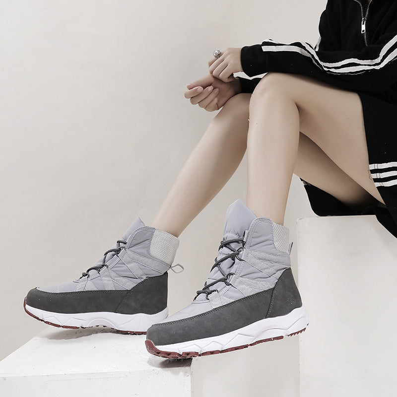 Gray lace-up snow boots with padded cuffs and quilted stitching, red tread outsole