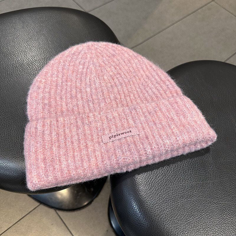 Pink ribbed knit beanie hat with folded brim and pipiswoot logo patch