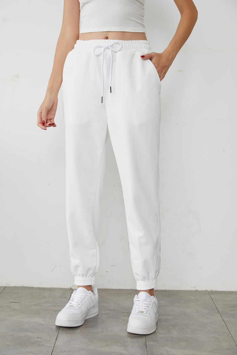 White high-waisted jogger sweatpants with drawstring hood and elastic ankle cuffs