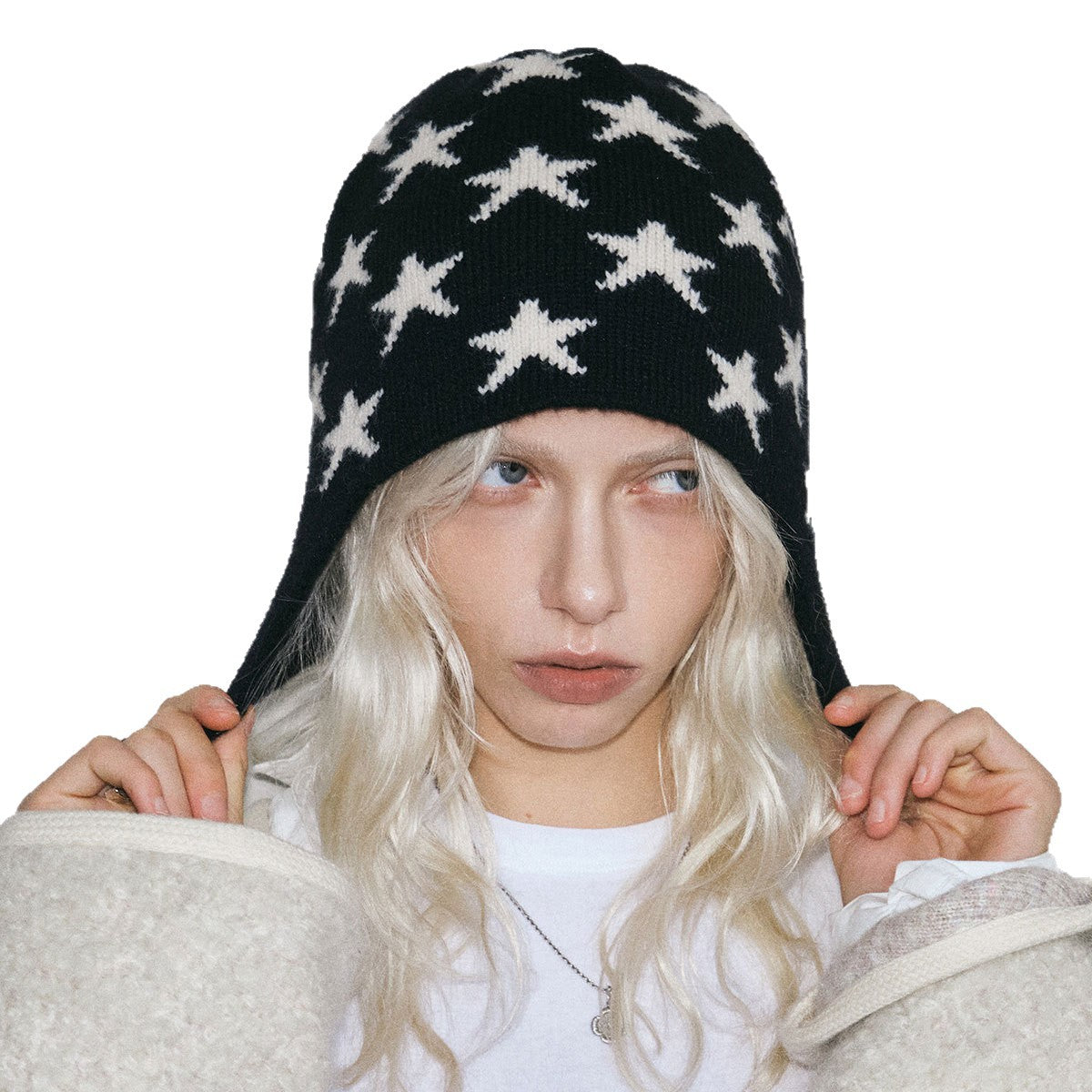 Black knit beanie with white stars, close-up of patterned knit, women’s winter hat
