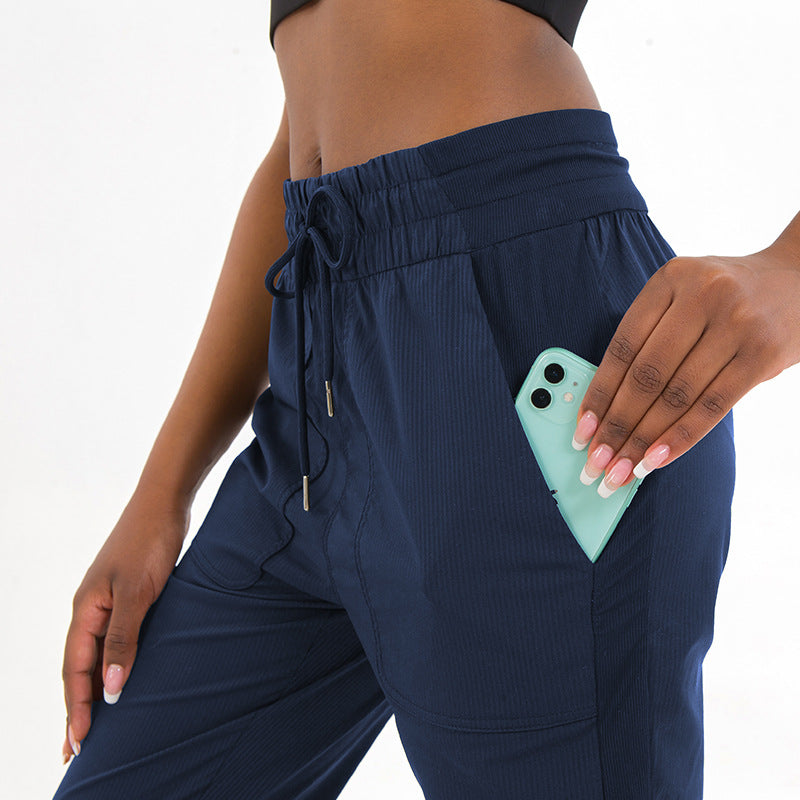 Navy jogger pants with drawstring waist, pocket details, and ankle cuffs
