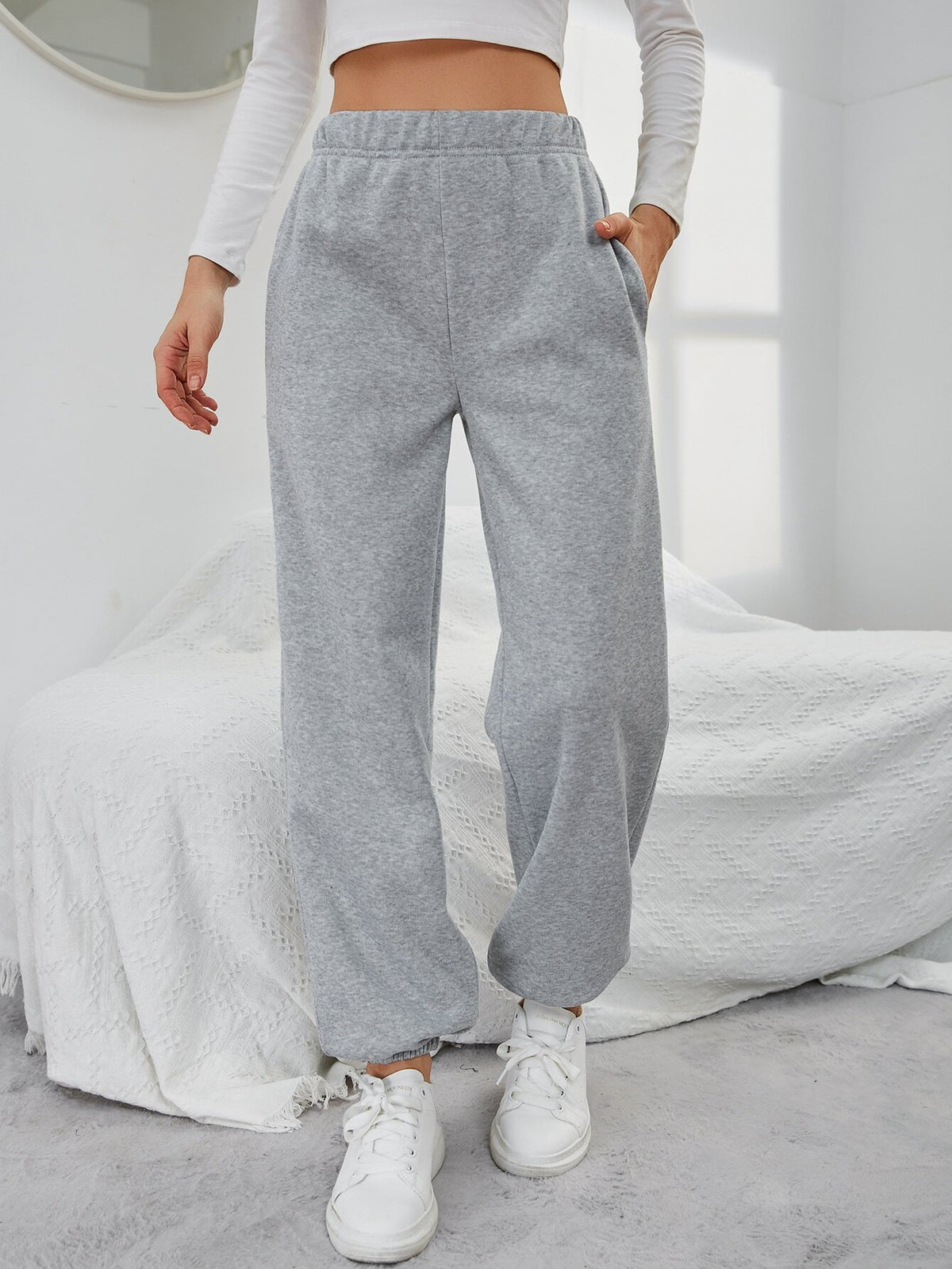 Grey high-waisted straight-leg sweatpants with side pockets and relaxed fit