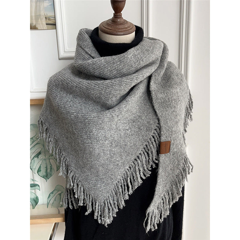 Gray large tassel triangle shawl with fringed border, draped over shoulders