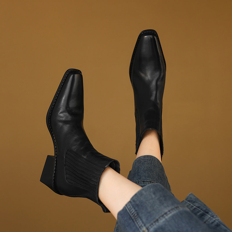 Black leather Chelsea boots with square toe and thick block heel, rear side view