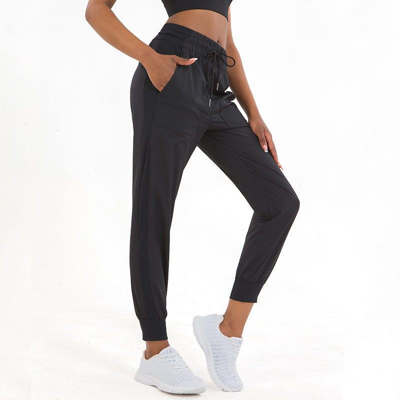 Black jogger pants with drawstring waist, side pockets, and tapered ankle cuffs
