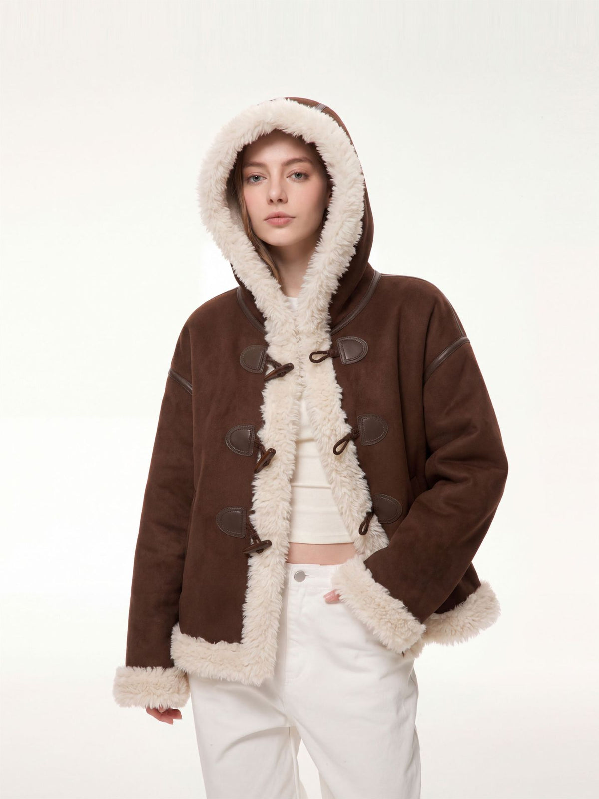 Women’s brown hooded suede shearling jacket with hood up and toggle-style front