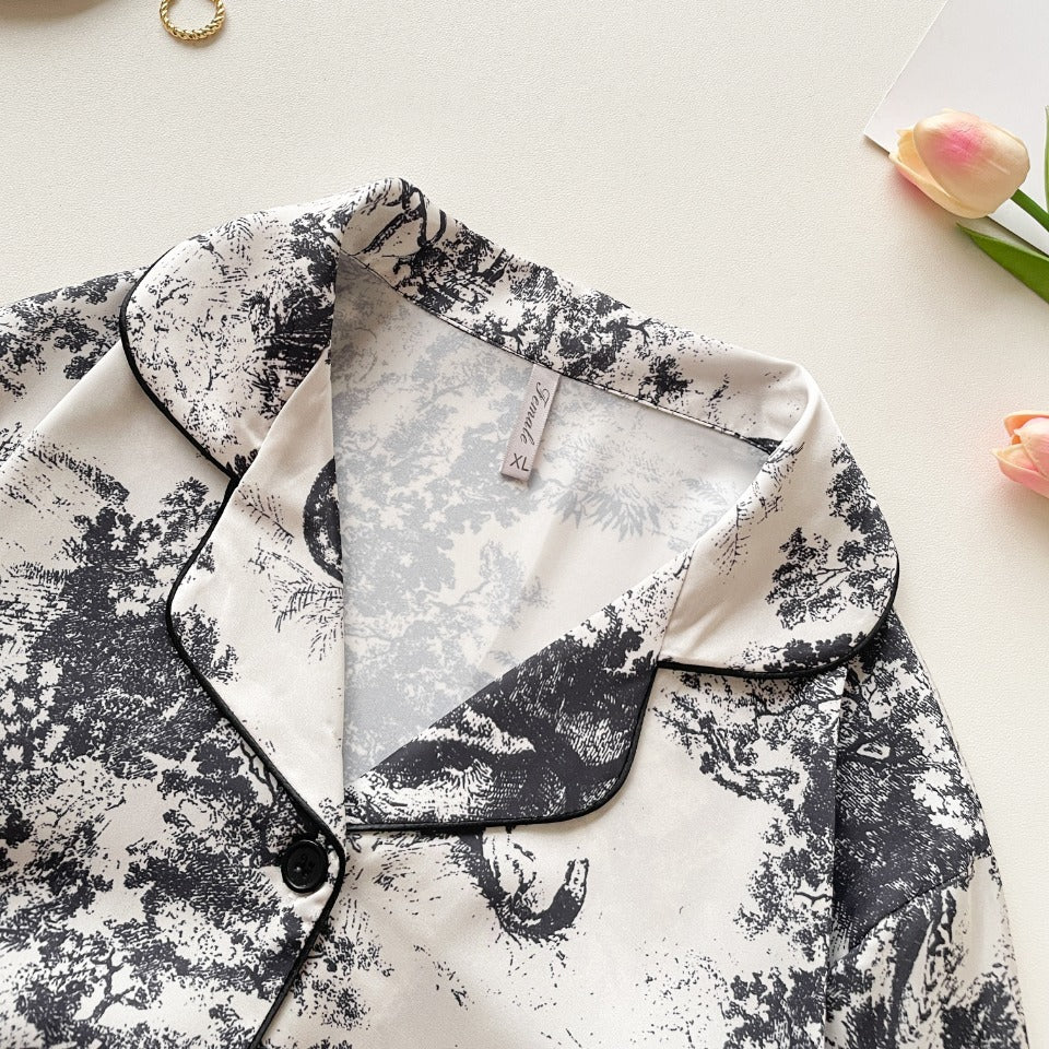 Black button-up pajama shirt with contrast trim and jungle print, close-up