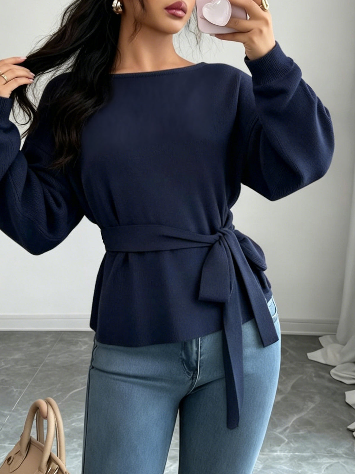 Women's dark blue long-sleeve sweater tied at the waist, shown with jeans