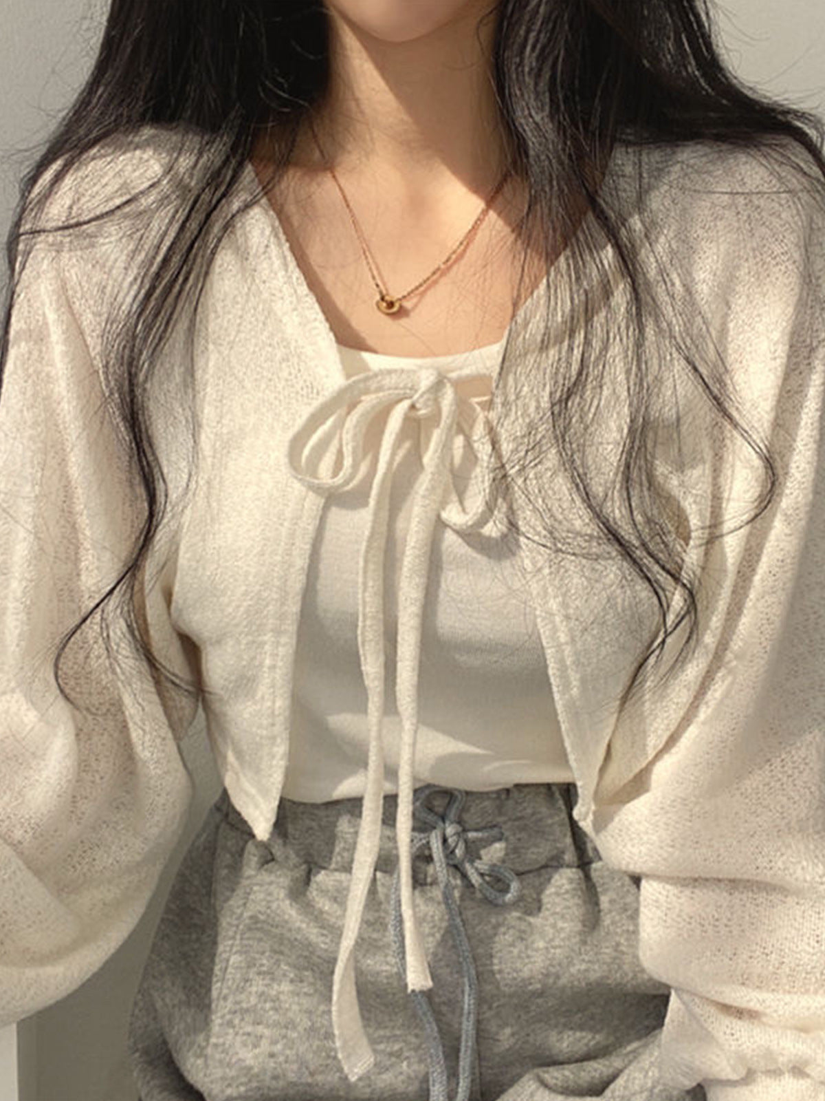 White cropped tie-front cardigan with long sleeves and bow-tie neckline open knit