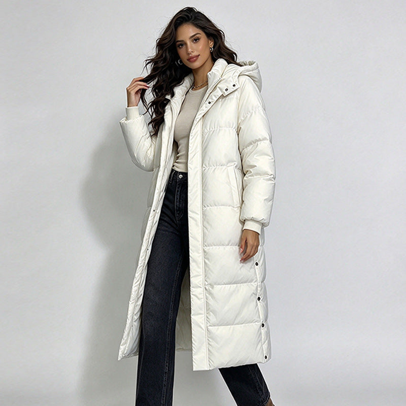 Women’s long white hooded puffer coat with button closure and side pockets.