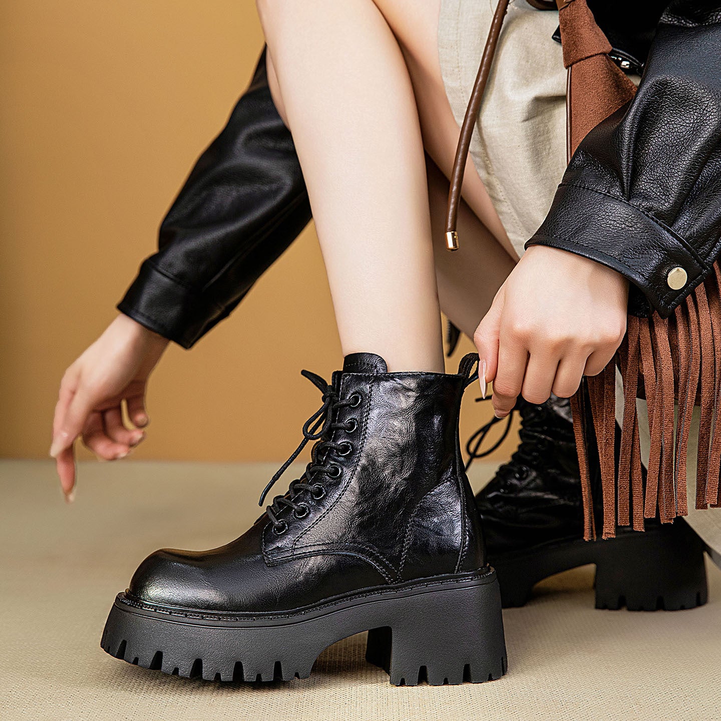 Black lace-up combat ankle boots on chunky platform with thick tread