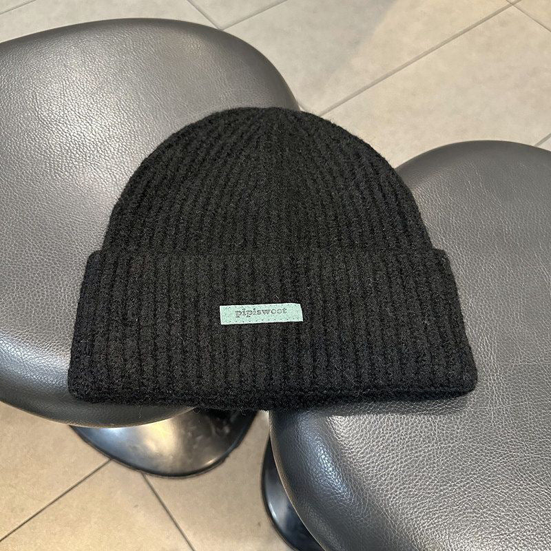 Black ribbed knit beanie hat with cuff brim and pipiswoot logo patch