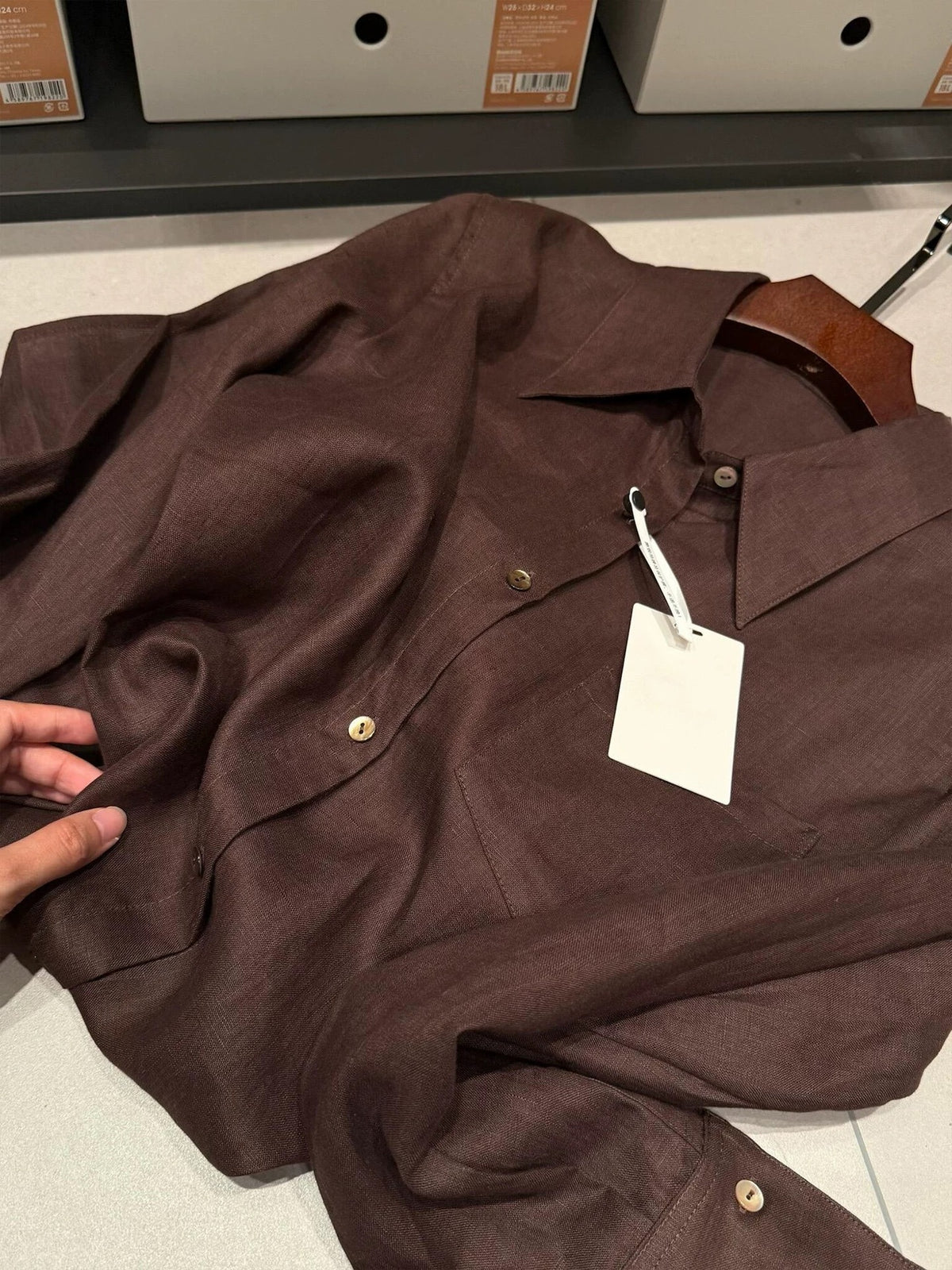Dark brown linen button-down shirt with point collar and twin chest pockets.