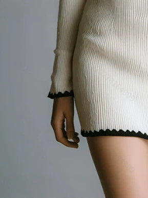 White ribbed knit mini dress with scalloped hem and cuffs, long sleeves