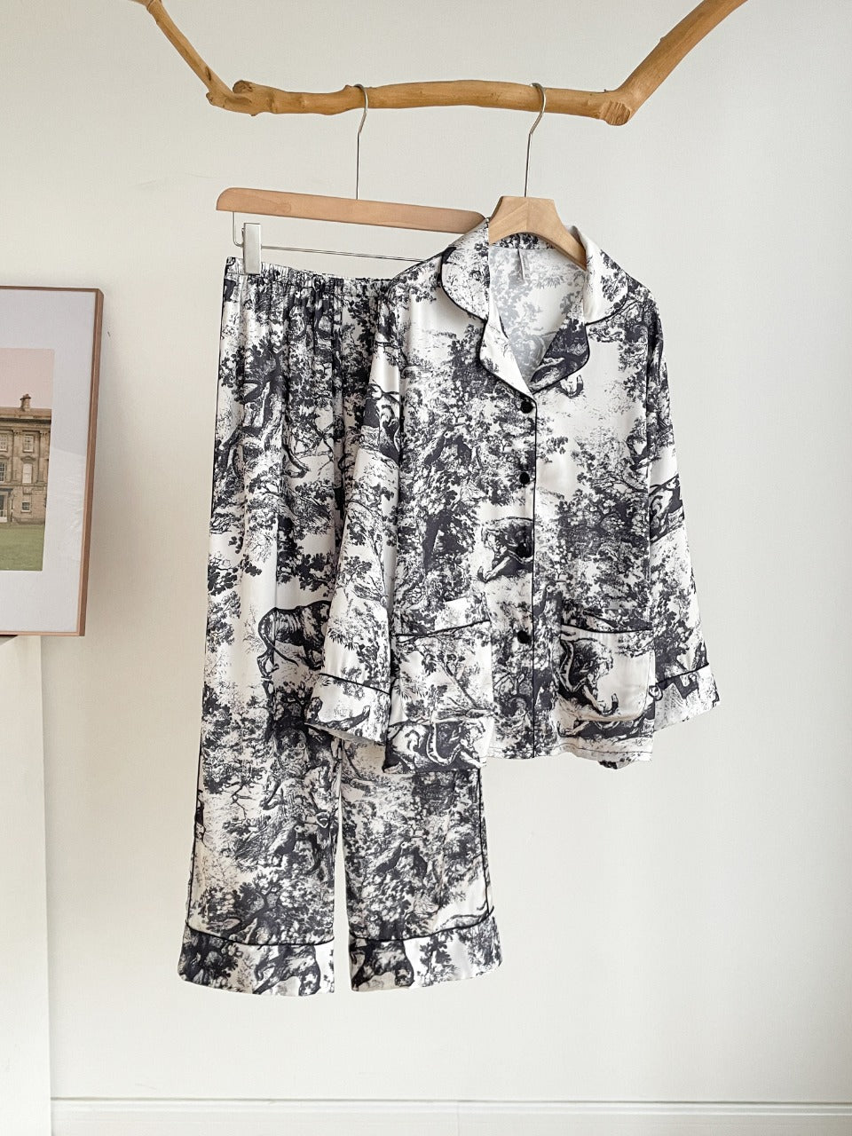 Girls’ black jungle print pajama set hanging on a hanger, button-up shirt and pants