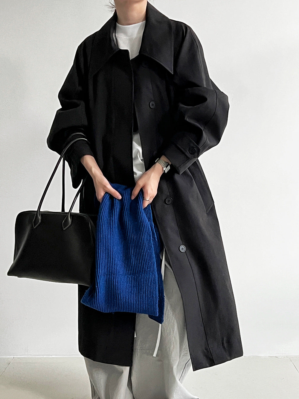 Women’s black long lapel trench coat with button front and tie-waist belt