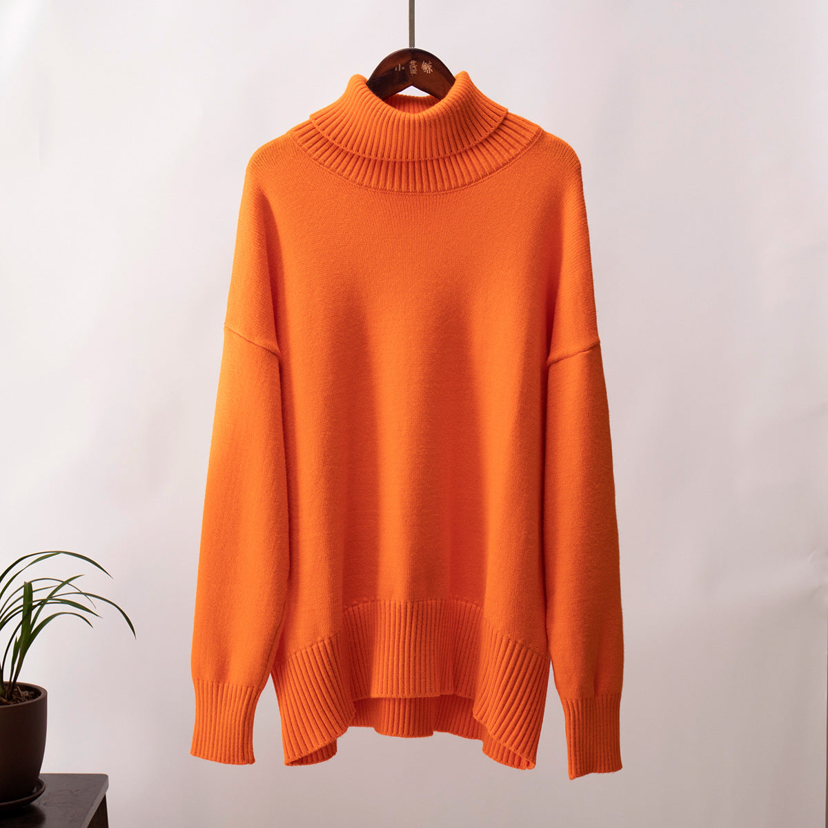 Orange knit turtleneck pullover sweater with loose fit and ribbed hem