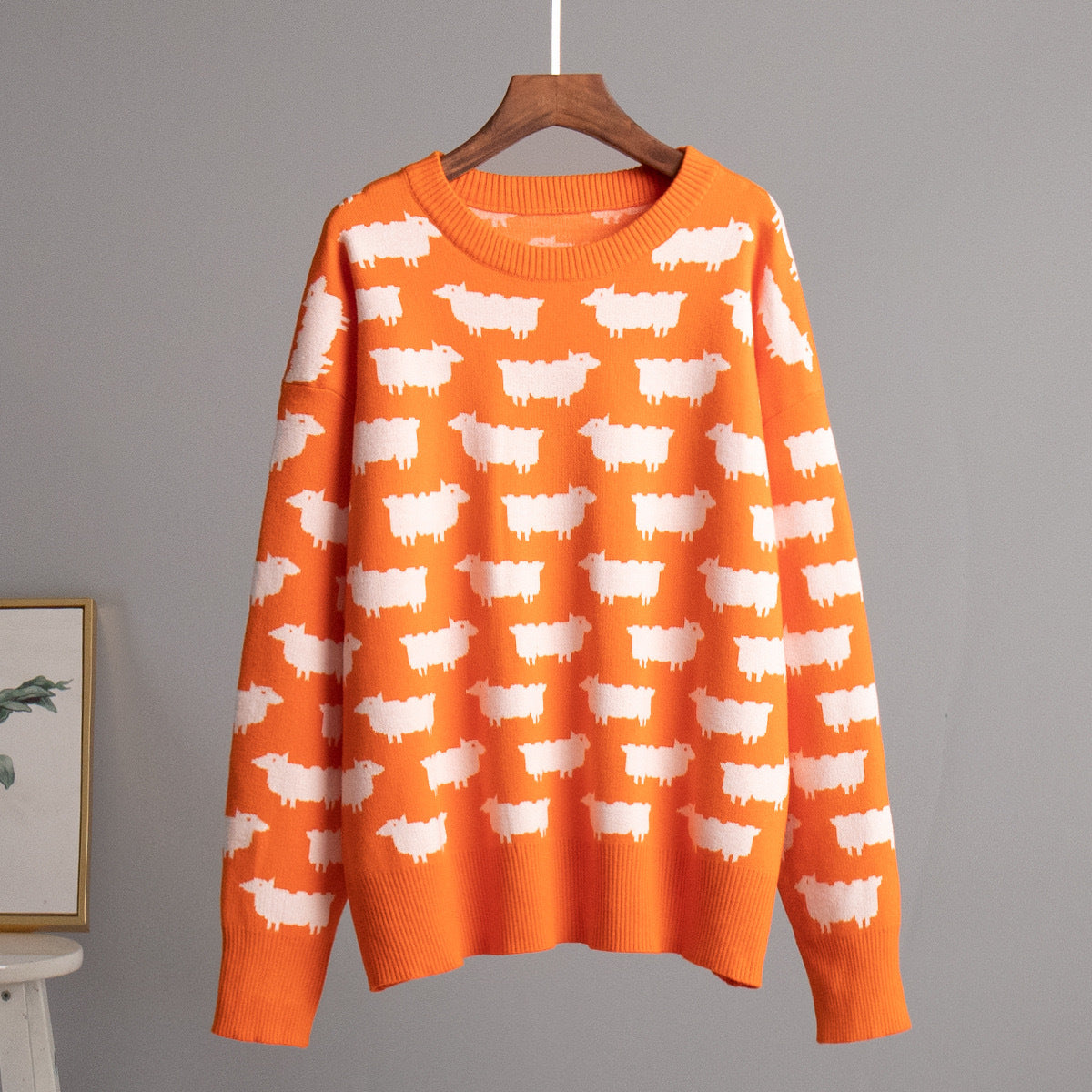 Women’s crewneck knit sweater, orange with white sheep pattern, long sleeves