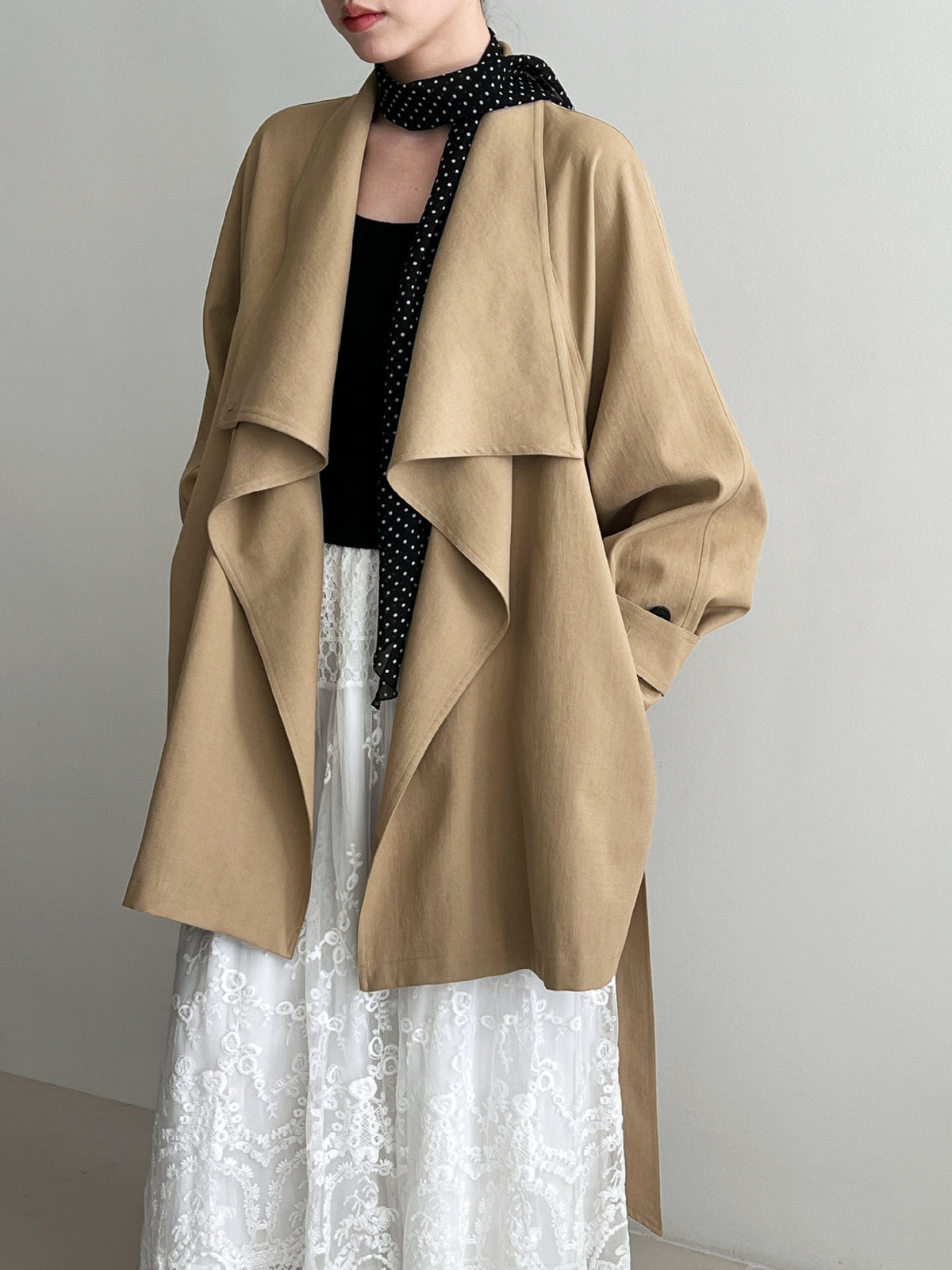 Women’s tan wrap coat with wide lapels and draped panels, long sleeves