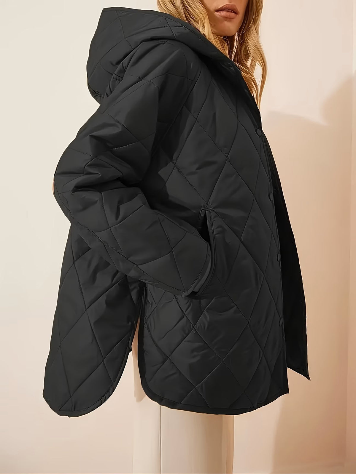 Black quilted hooded coat sleeve and hood detail, oversized fit