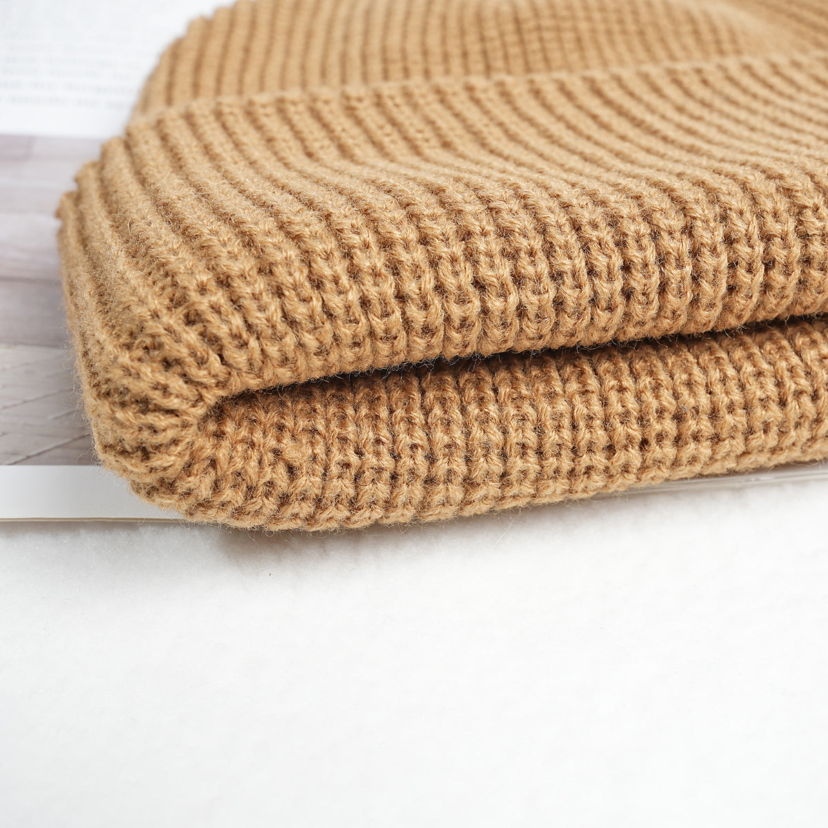 Thick knitted beanie hat in tan with textured ribbed knit and folded brim