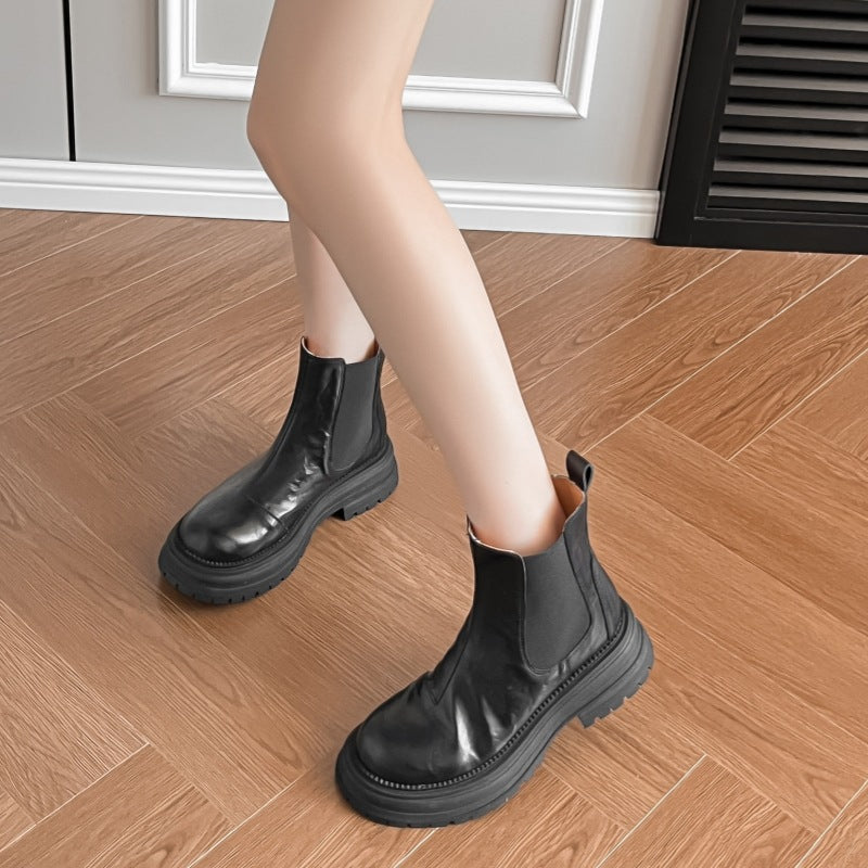 Black leather platform Chelsea boots with elastic side panels and chunky lug sole on model