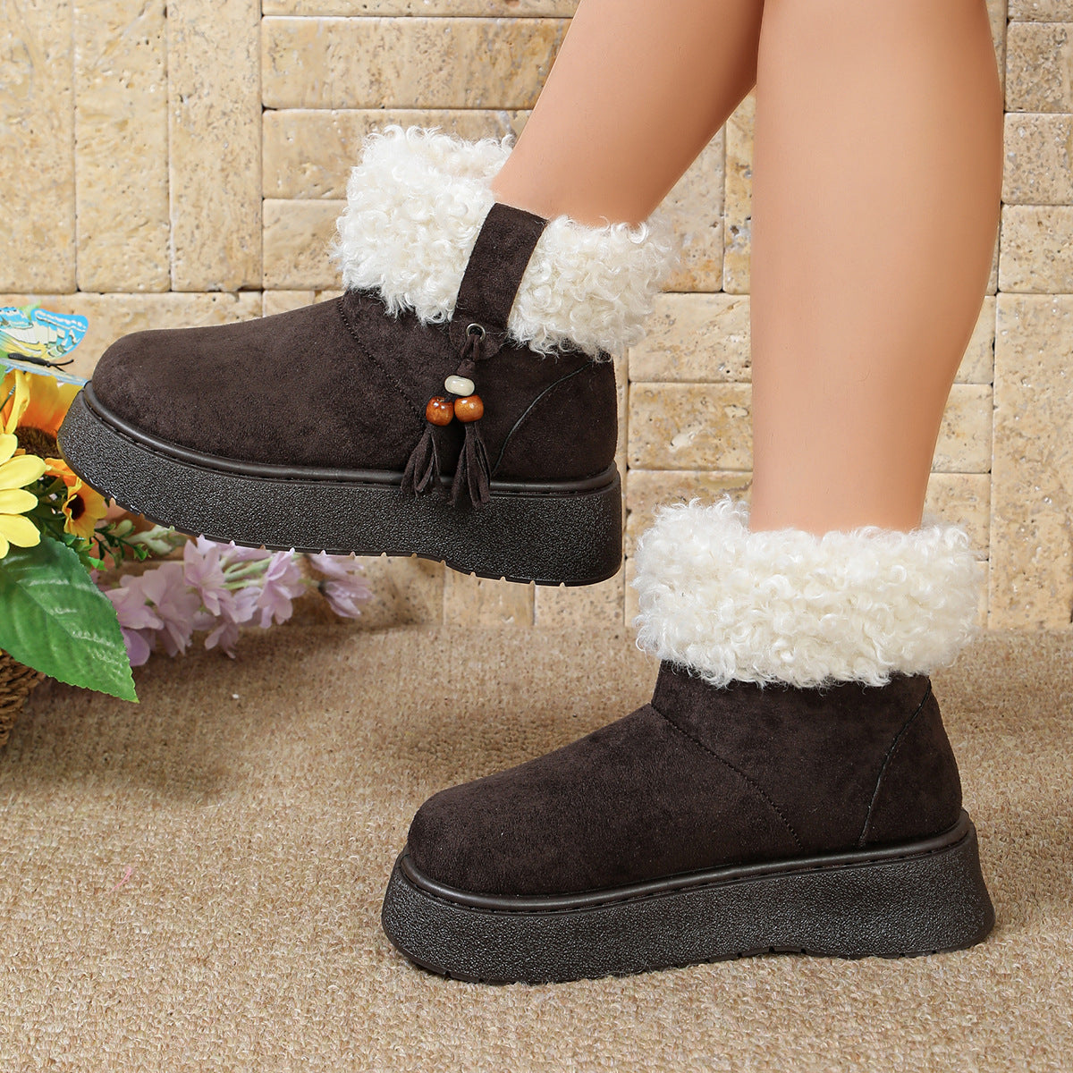 Black suede slip-on boots with white fuzzy cuffs and bead tassel ornaments