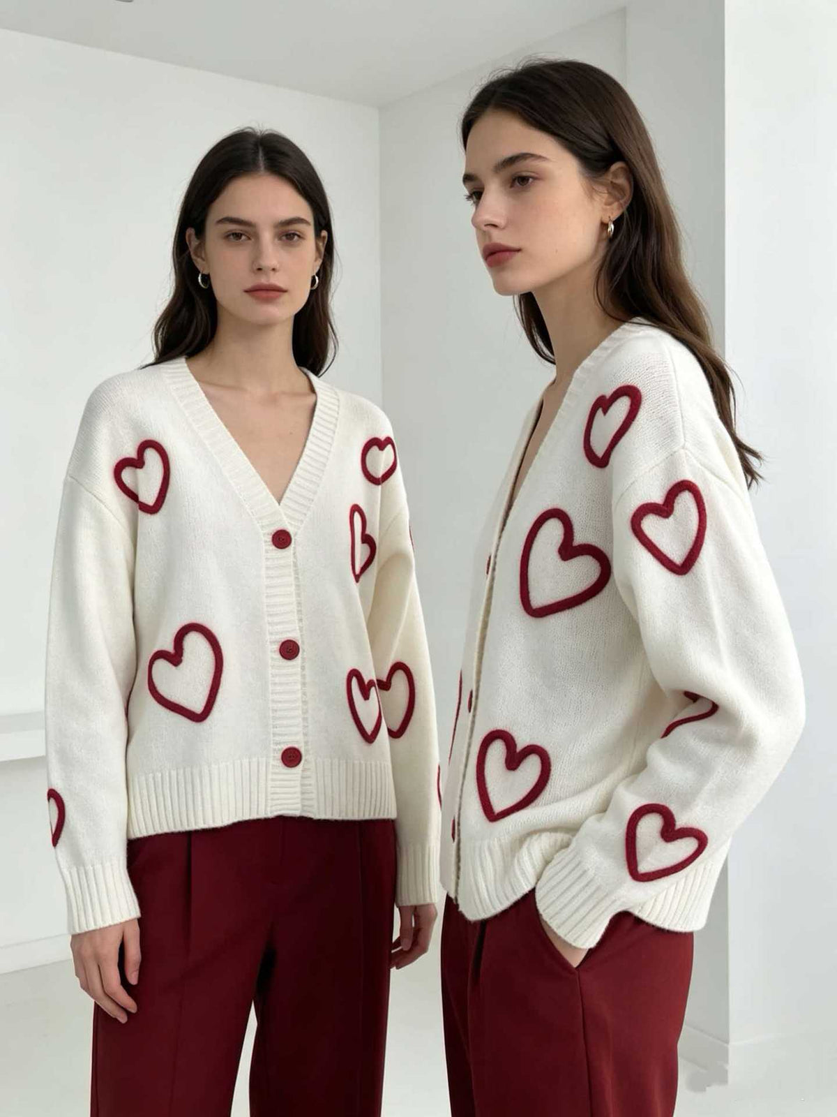 White V-neck knit cardigan with pink heart pattern, button front and long sleeves