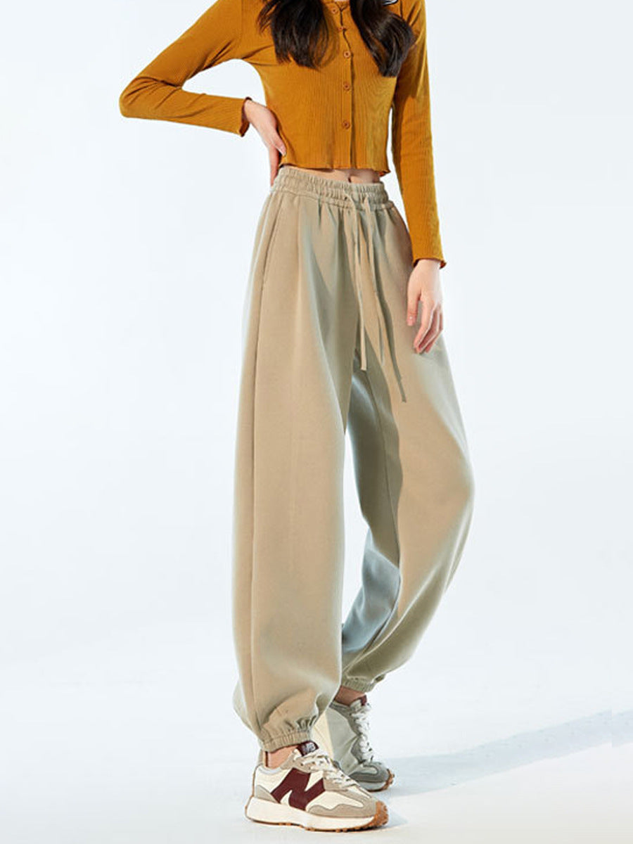 Beige high-waist jogger sweatpants with drawstring and loose straight legs.
