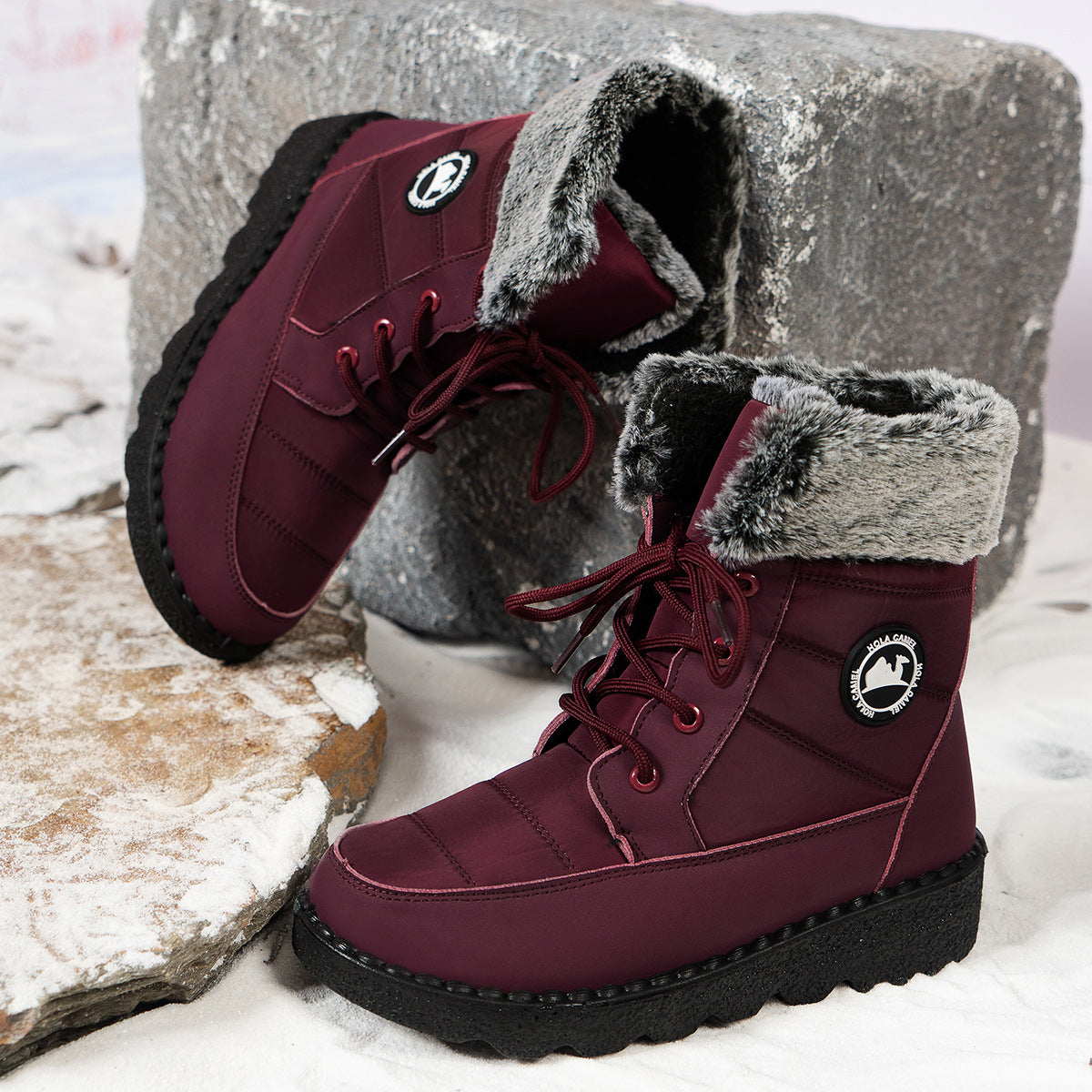 Burgundy lace-up winter boots with faux-fur cuff, side logo patch, and chunky sole