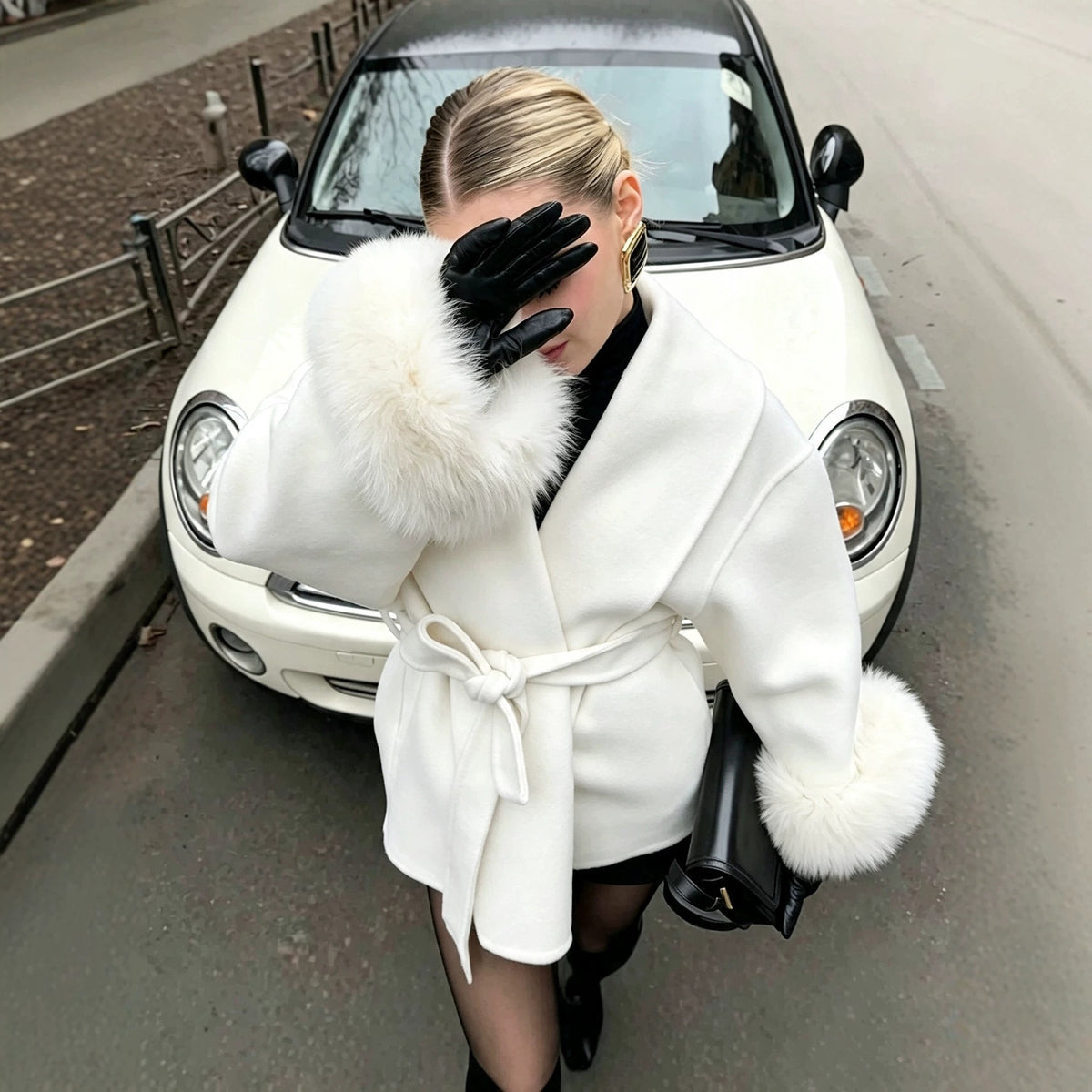 White wool wrap coat with tie belt and fluffy faux fur cuffs, front view.