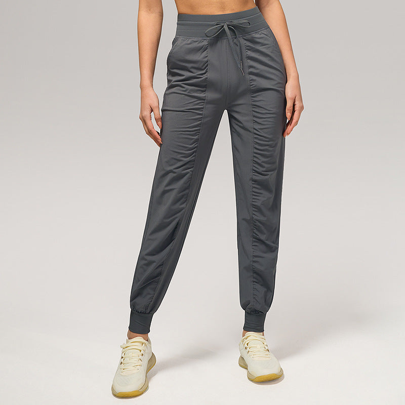 Women’s loose charcoal gray jogger pants with drawstring waist and cuffed ankles, side pockets.