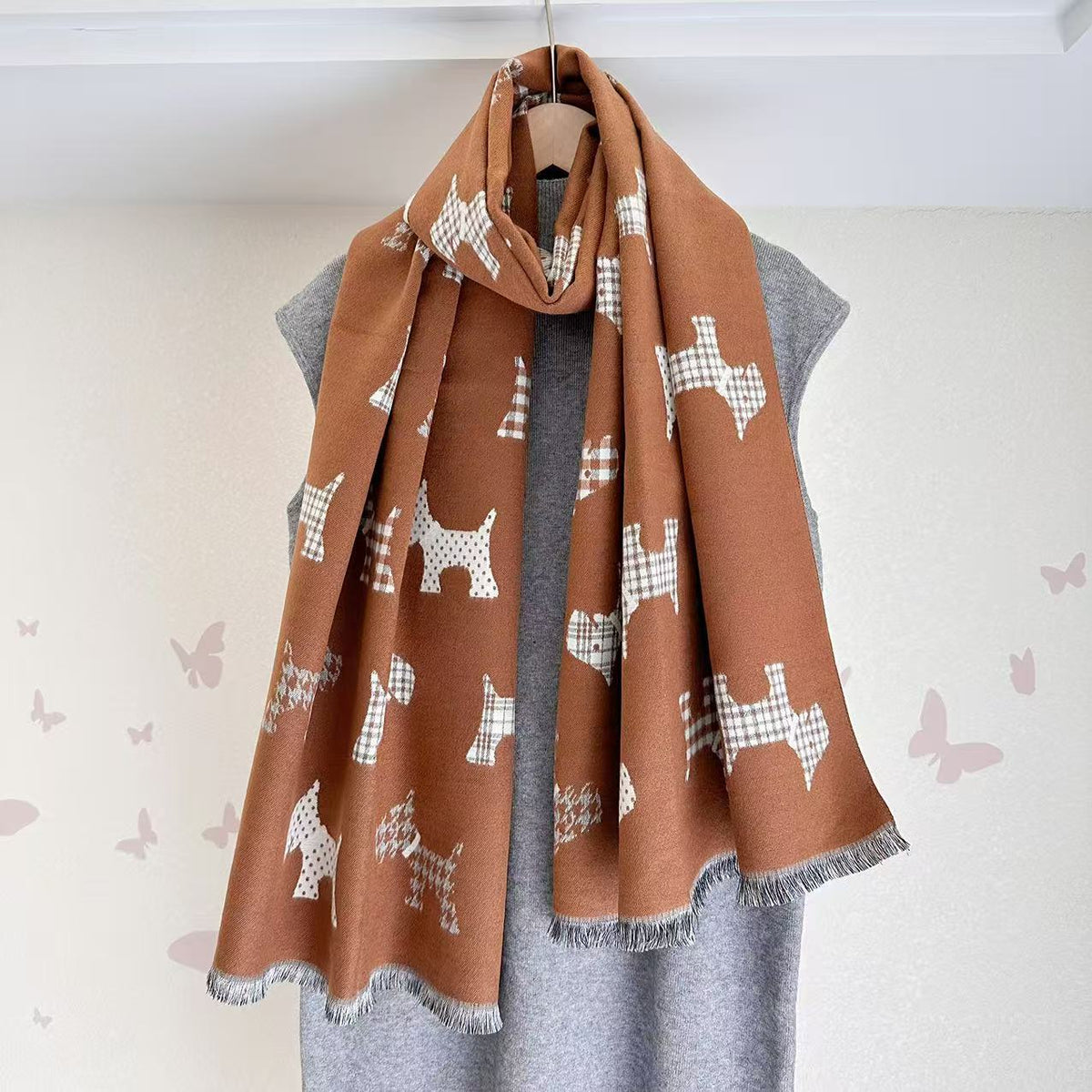 Rust brown scarf with dog motifs and fringed ends, draped around the neck