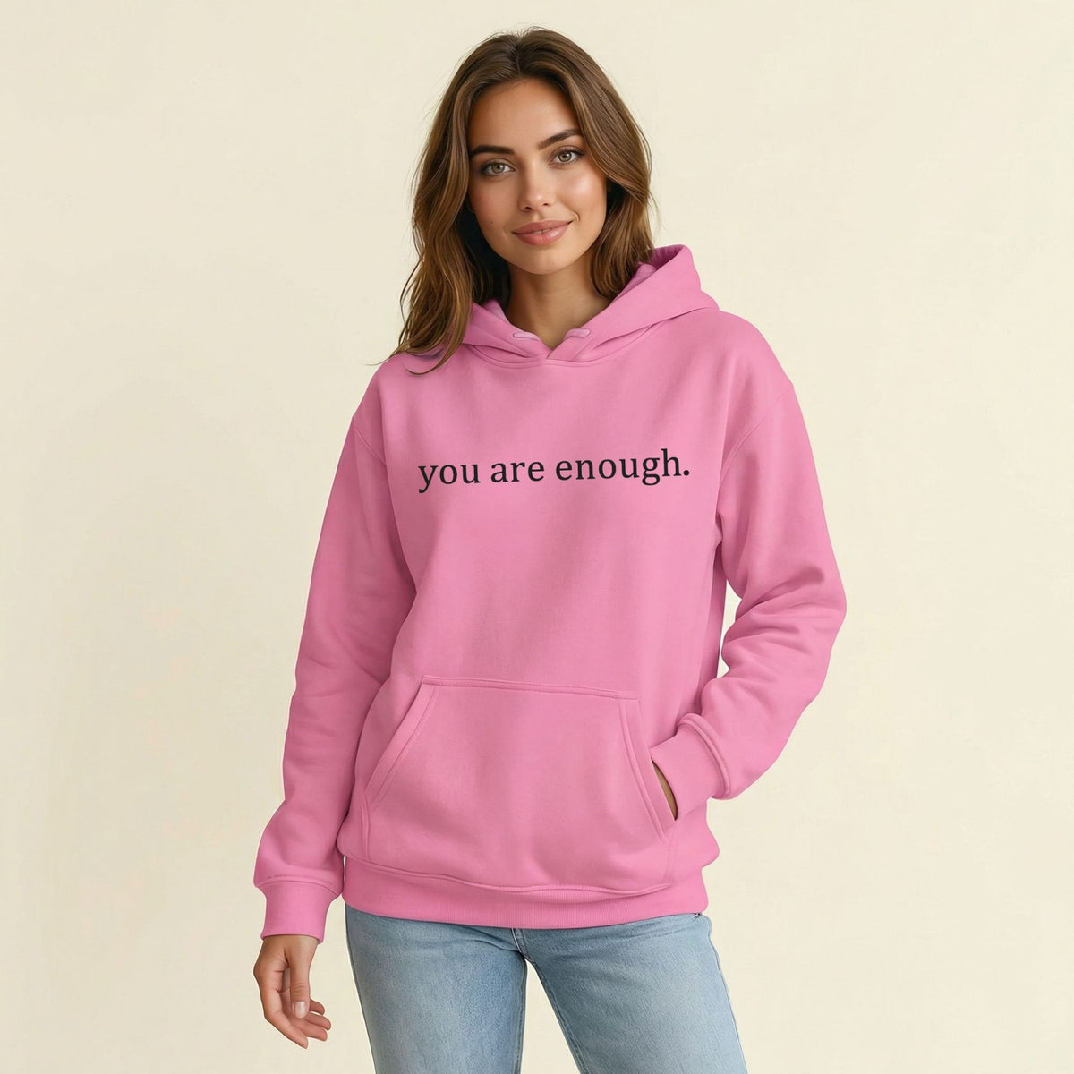 Pink women’s hoodie sweatshirt with hood, front pocket, and 'you are enough' print.