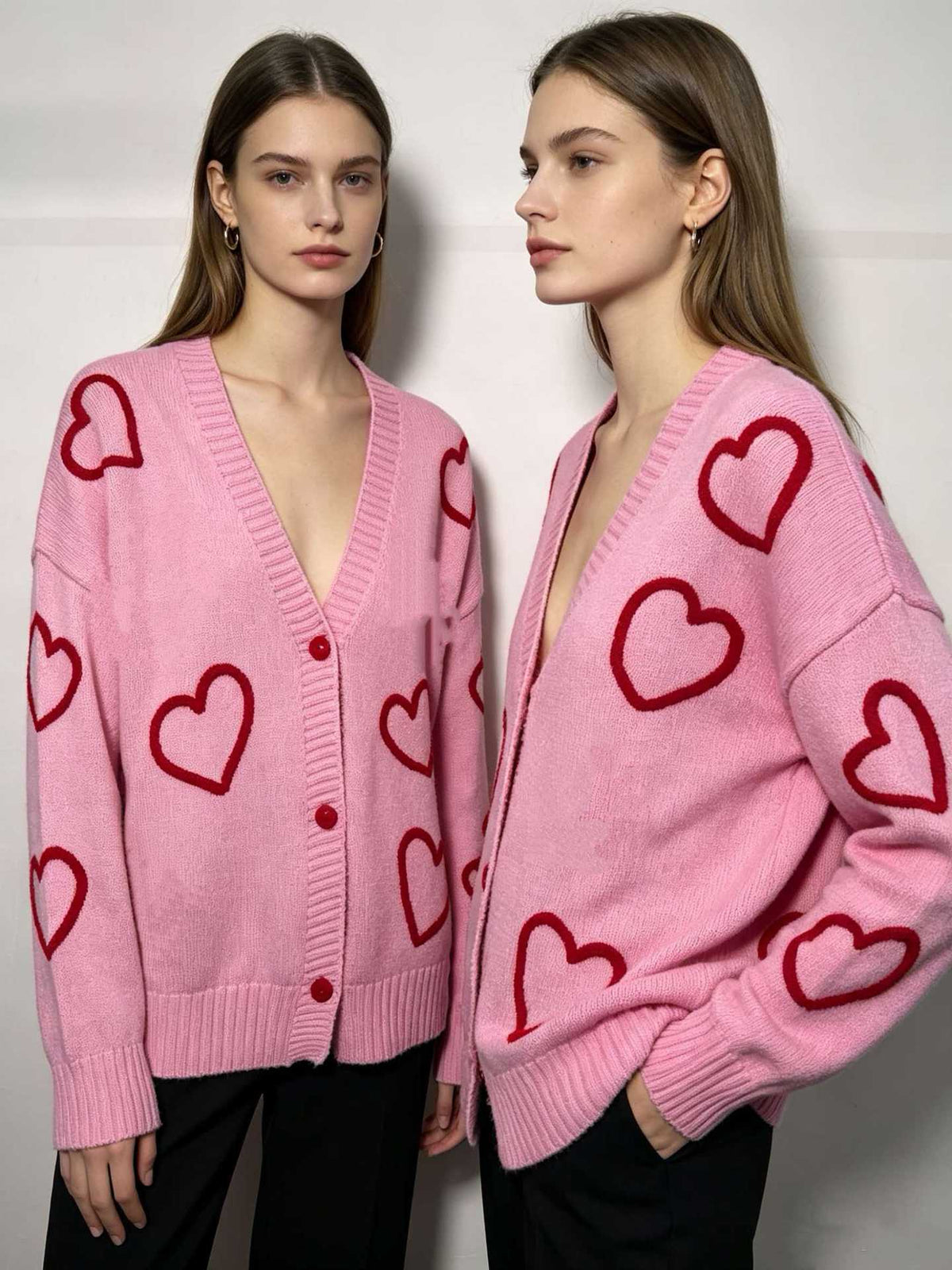 Pink V-neck knit cardigan with red heart pattern and button placket