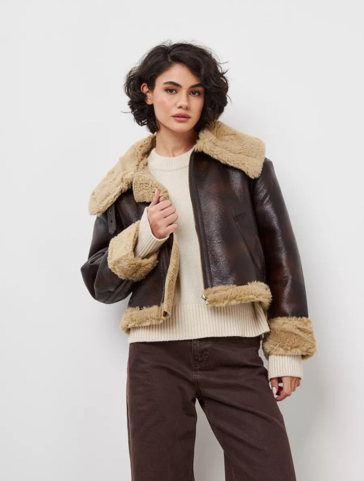 Women's brown leather jacket with tan shearling collar, zip front, and ribbed hem