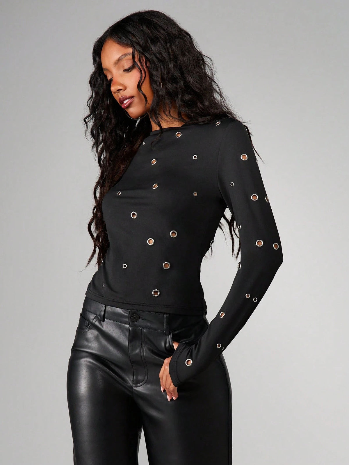 Women’s black long-sleeve round-neck top with metal eyelet grommet accents