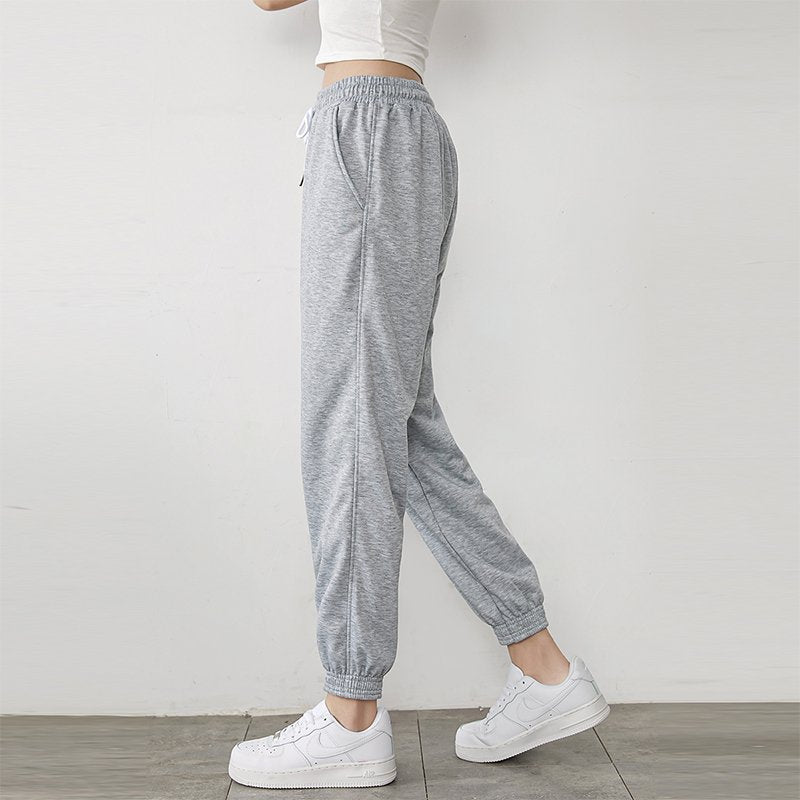 Light gray high-waisted jogger sweatpants with drawstring and tapered cuffs