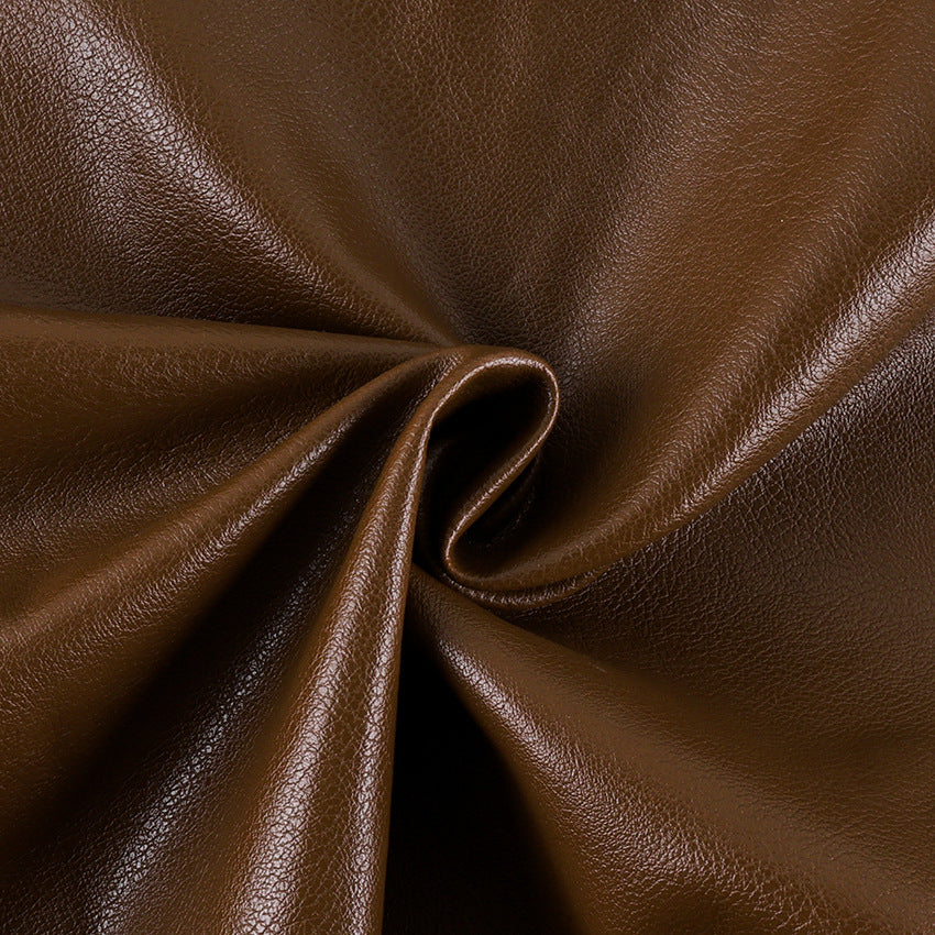 Brown leather jacket fabric close-up with smooth textured finish