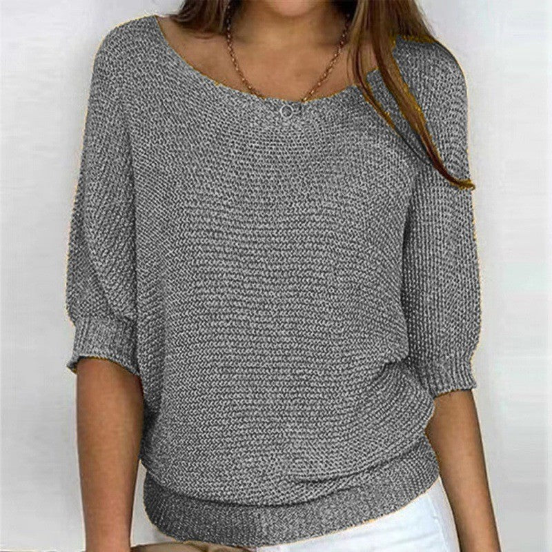 Gray knit top with round neck and three-quarter sleeves, ribbed hem and cuffs