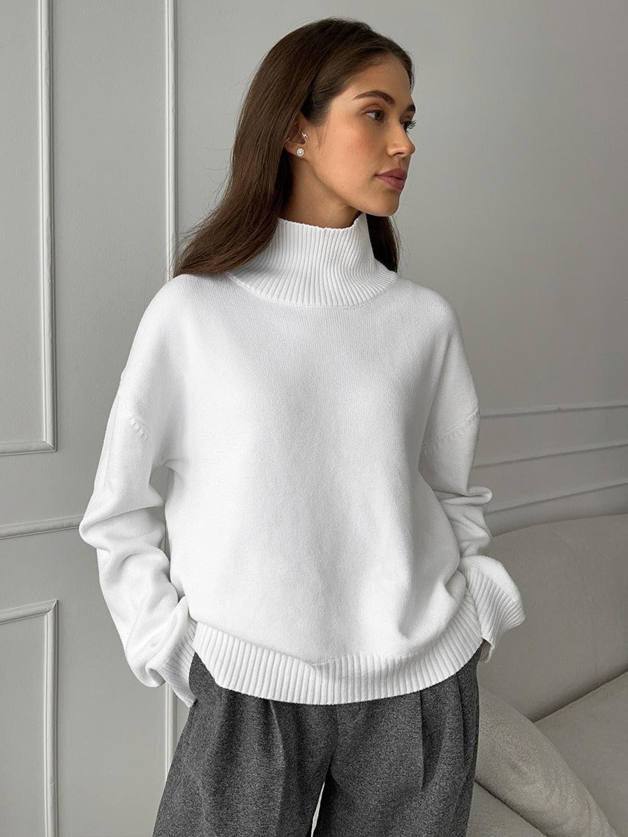 Loose turtleneck knit sweater in white, high ribbed collar, relaxed fit.