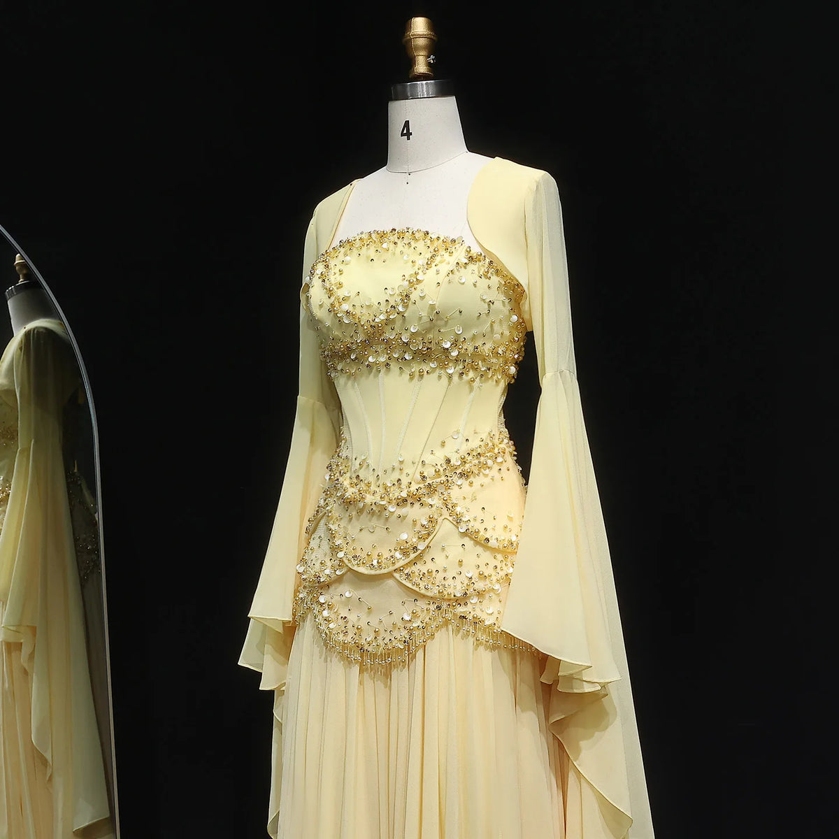 Pale yellow beaded corset evening gown with long, layered bell sleeves