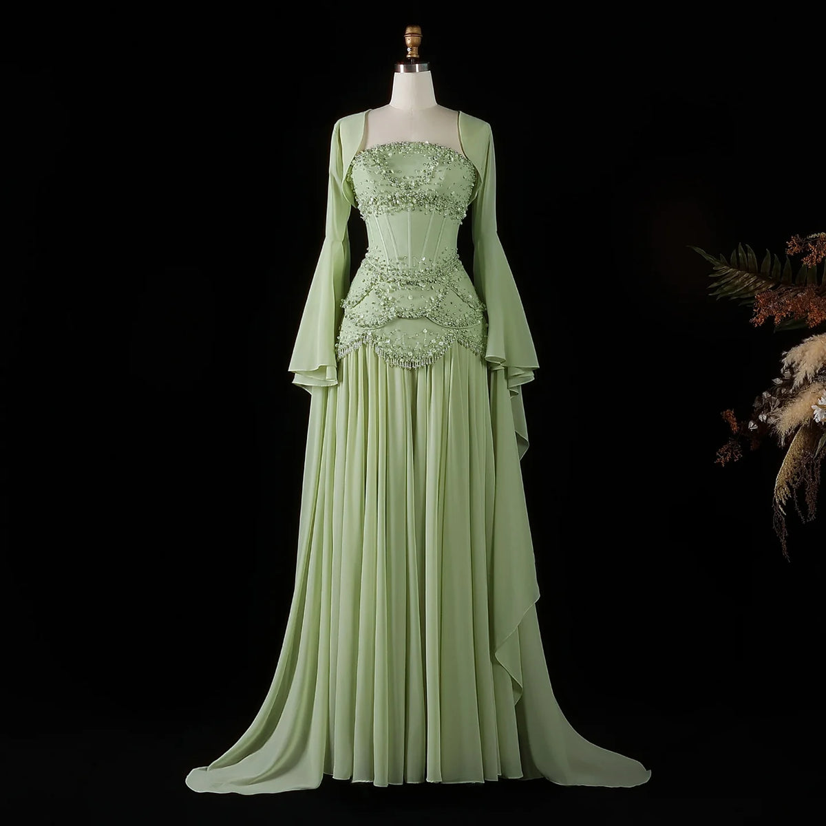 Sage green beaded corset evening gown with a flowing skirt and long flared sleeves