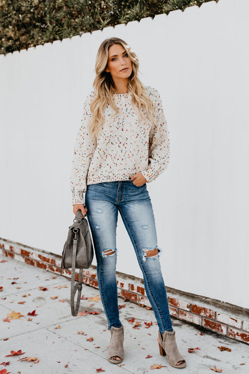 Beige dot-speckled knit sweater with crew neck and long sleeves, full outfit view