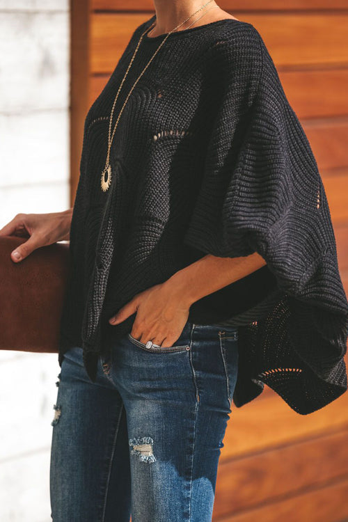 Black oversized knit sweater with bat-wing sleeves and arched dotted stitching